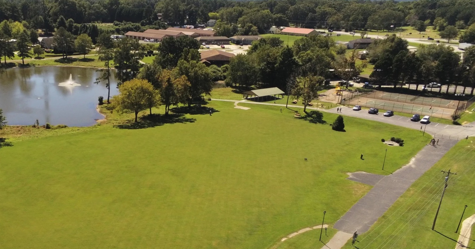 Aerial view of Shamrock Park with its lake, lawn, pavilion, courts and walking paths.