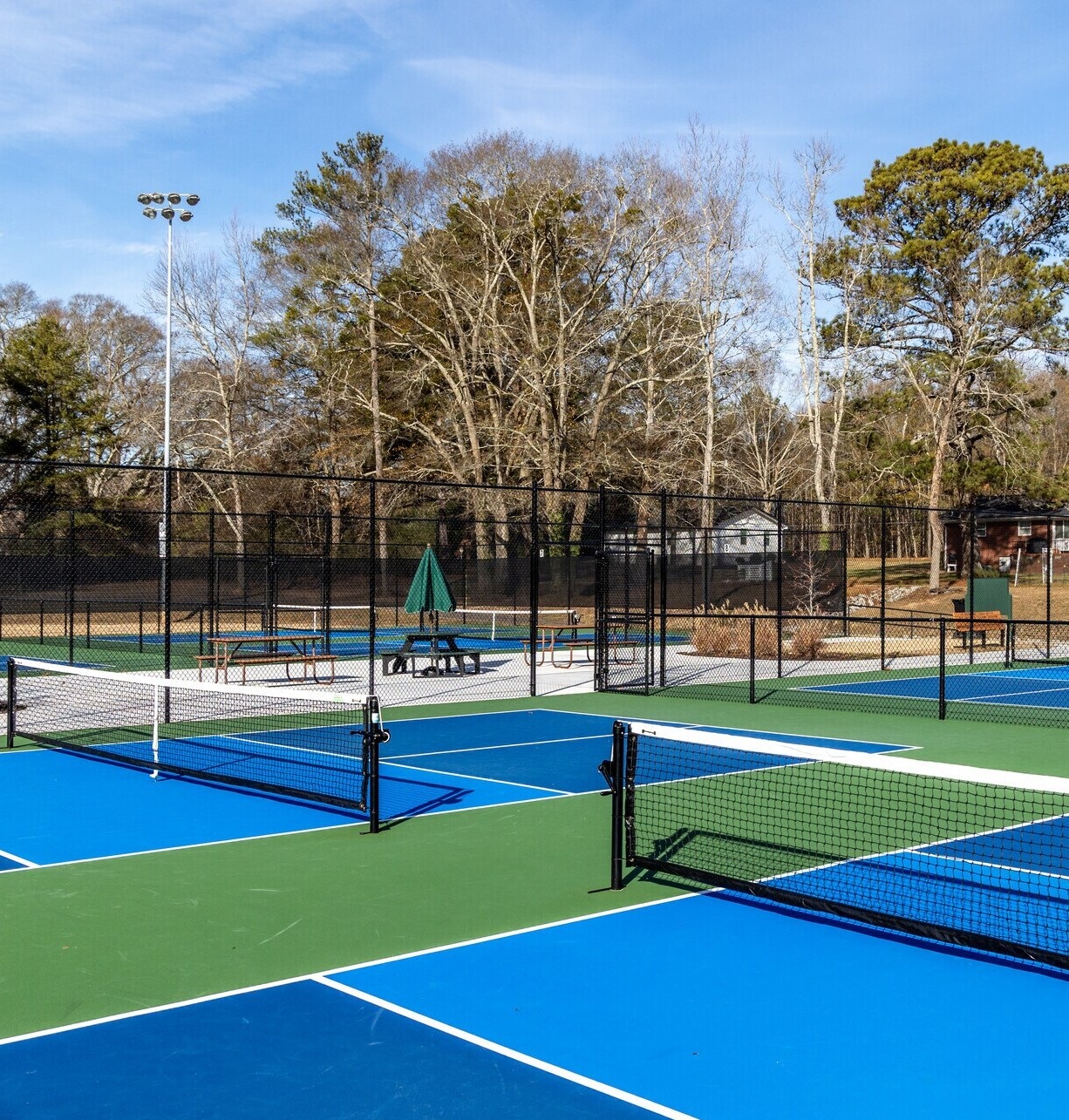 Blue and green pickleball courts with nets at a Tyrone recreation facility.